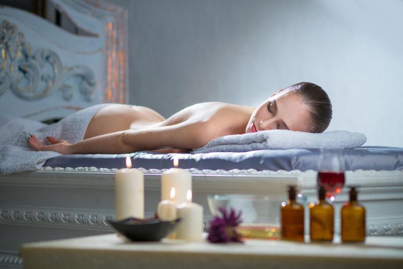 欧洲女孩在温泉沙龙的按摩桌上休息