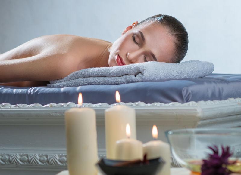 水疗中心的美女享受油浴蜡烛沙龙