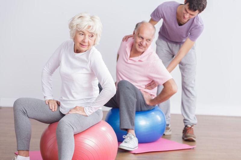 老夫妻坐在瑜伽垫上健身