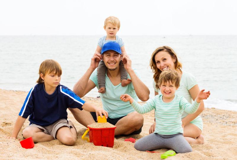 父母带着孩子在沙滩上玩耍