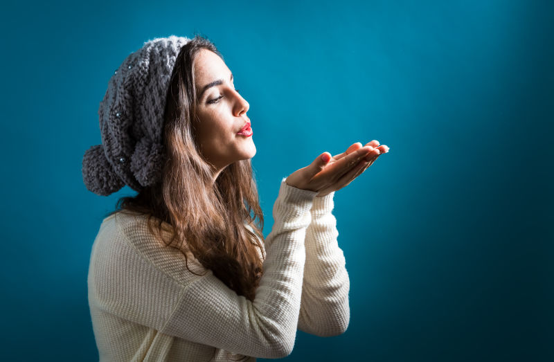 年轻女子穿着秋冬装吹一个吻