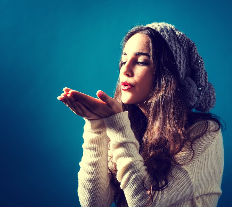 快乐的年轻女子双手吹一个吻