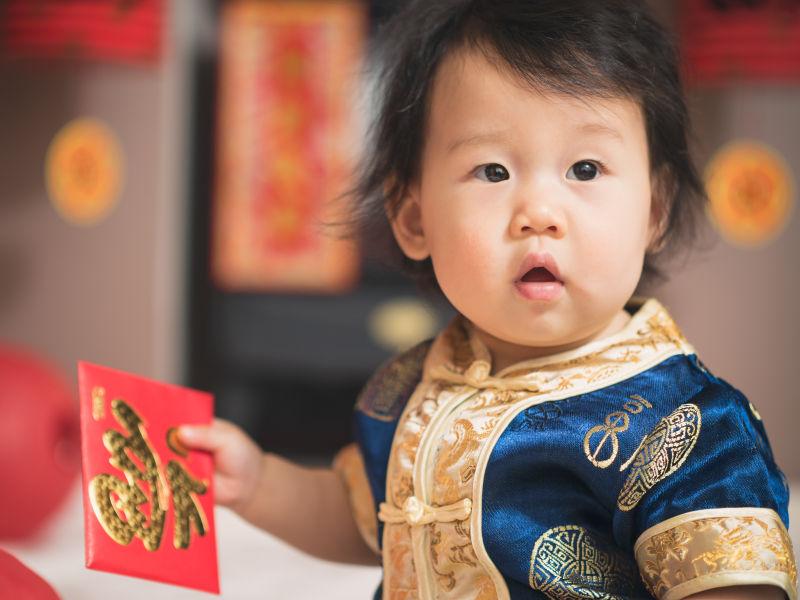 拿着红包的快乐女婴儿