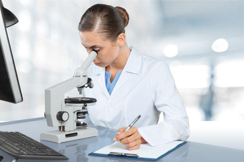 坐在实验室使用显微镜的女性研究人员