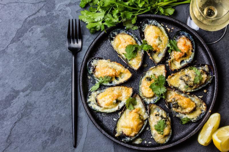 黑色盘子里的贻贝柠檬片和香槟酒等