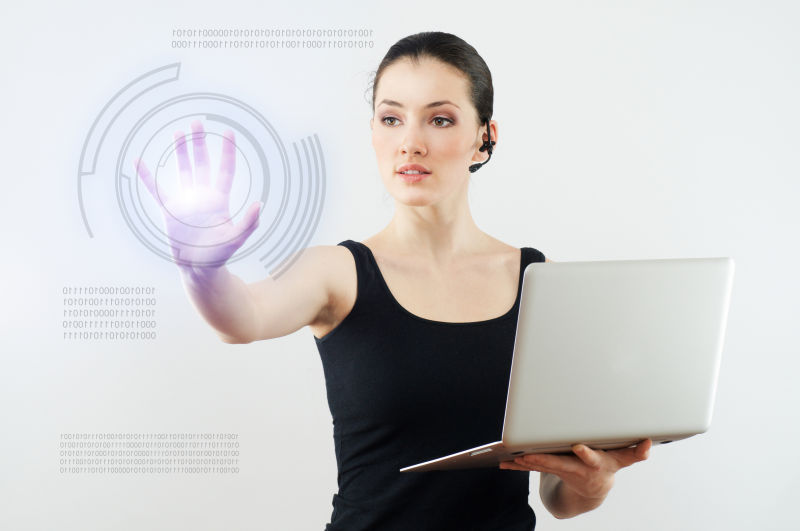 灰色背景中带着耳机用笔记本体验新系统的女人