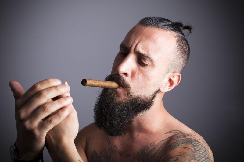 嘴里含着雪茄点火的男人