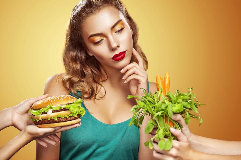 年轻性感女人选择汉堡包和素食
