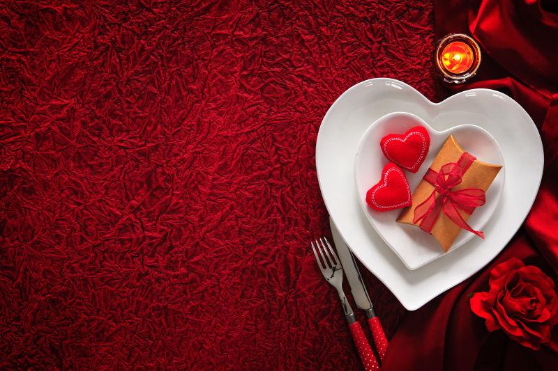 红色桌布上的餐具与情人节小礼物