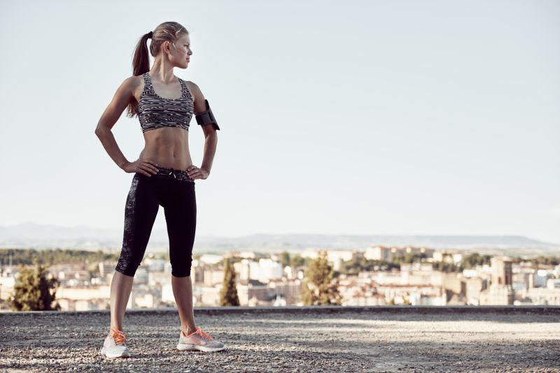 站在岩石路外的美丽的健身女运动员