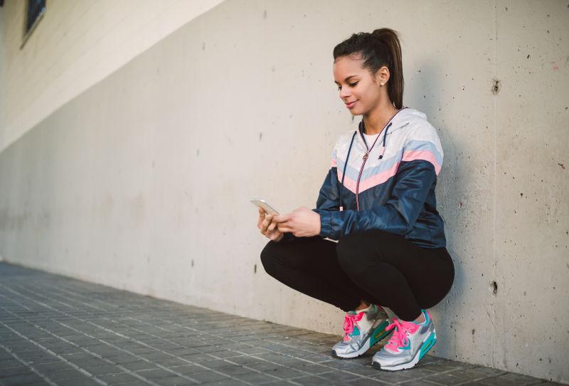 西班牙美女流氓蹲看她的智能手机