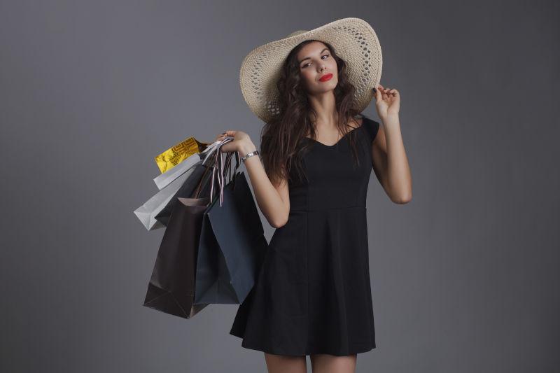 拎着不同的购物袋的美女在演播室拍摄