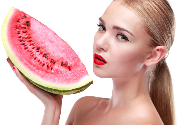 拿着西瓜的有美丽妆容的美女