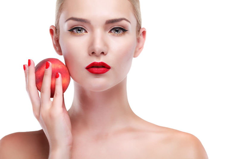 拿着桃子的有着时尚妆容的美女