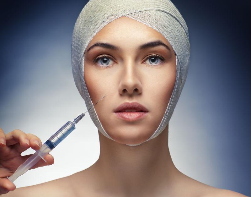 绷带包裹着头部的美女注射肉毒杆菌素微整形