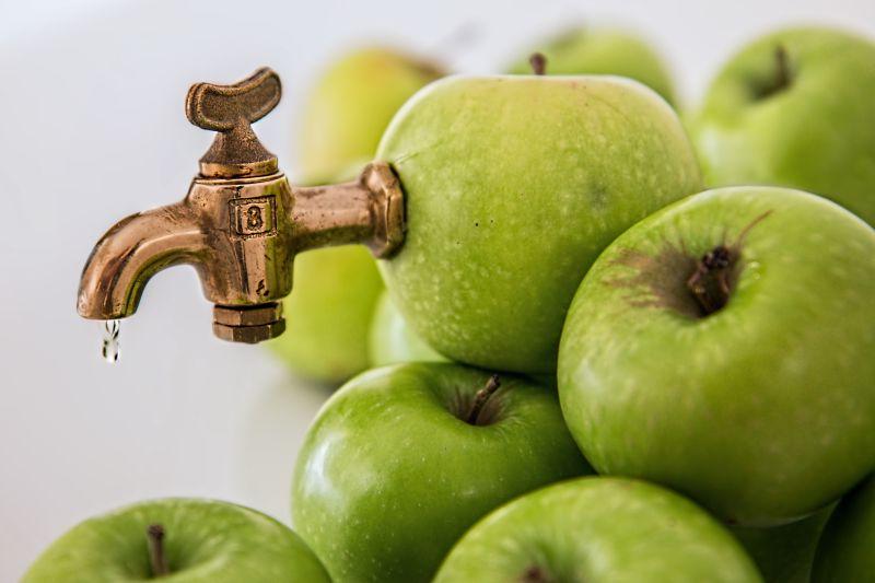 青苹果上的水龙头压榨果汁