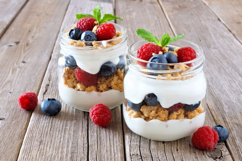 放在木桌上的蓝莓覆盆子酸奶