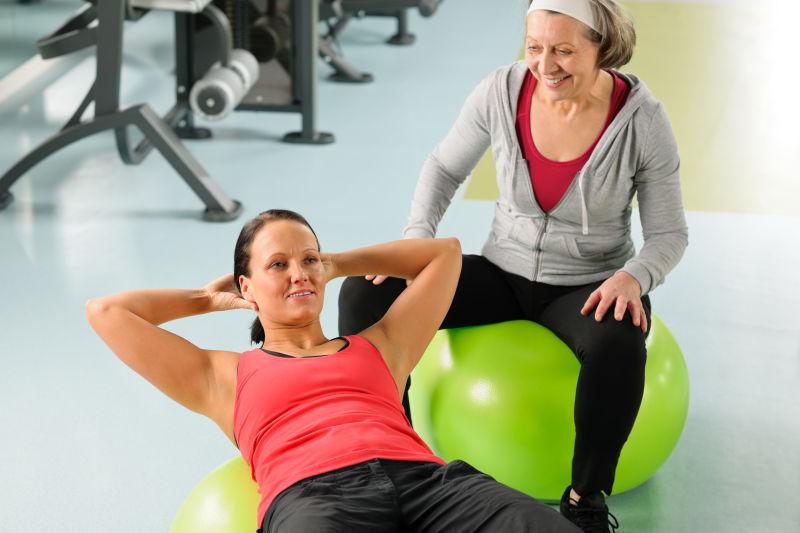 健身房里在瑜伽球上做锻炼的女人