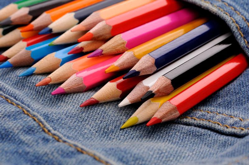 蓝色牛仔裤口袋里的一套彩色铅笔