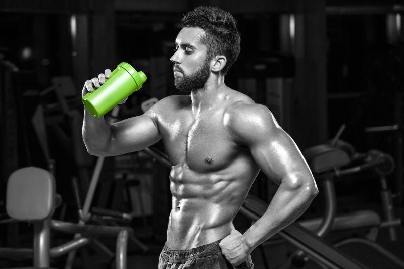 性感肌肉男在健身房饮水