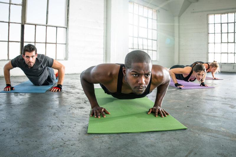 房间里俯卧撑锻炼的四个年轻人