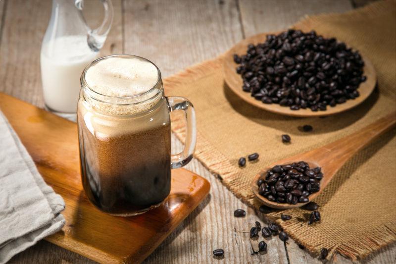 玻璃杯里的牛奶咖啡和咖啡豆