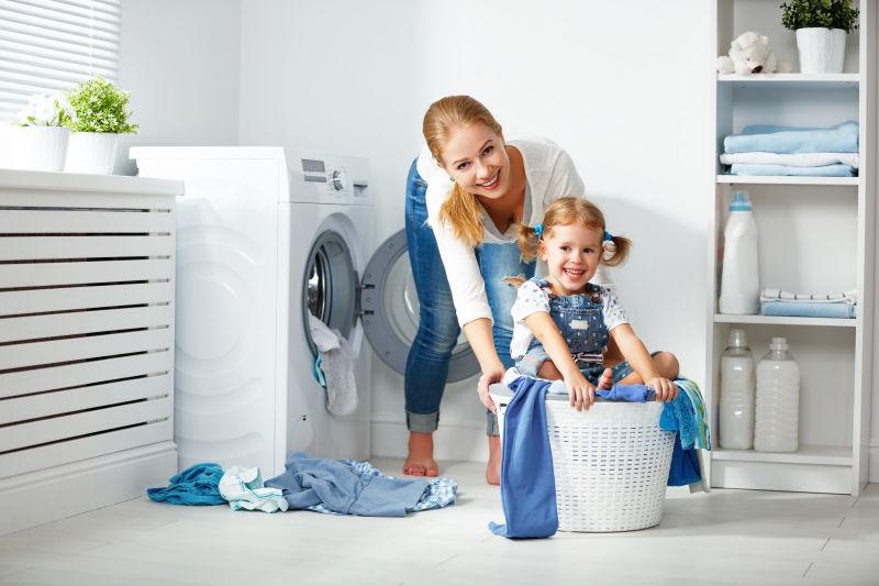 洗衣机旁准备洗衣服的母女