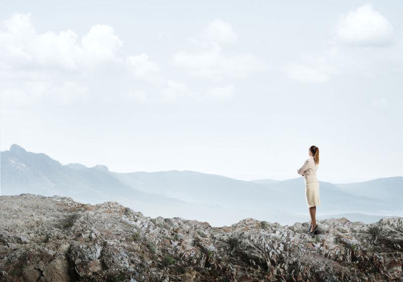 岩石上眺望远方的女商人