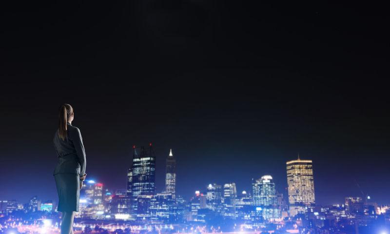 夜色下看着美丽的夜景的女商人
