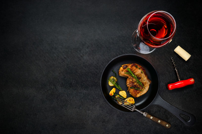 平锅上的烤牛排配玫瑰酒