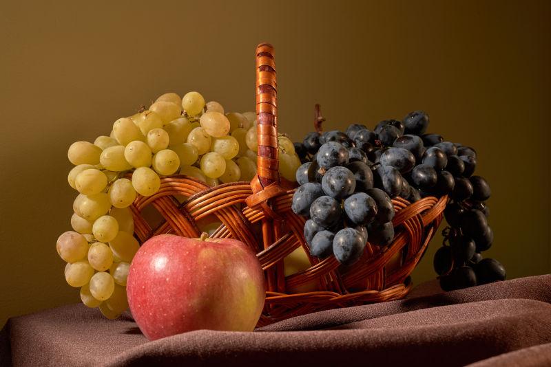 放在果篮里的新鲜美味的葡萄和苹果