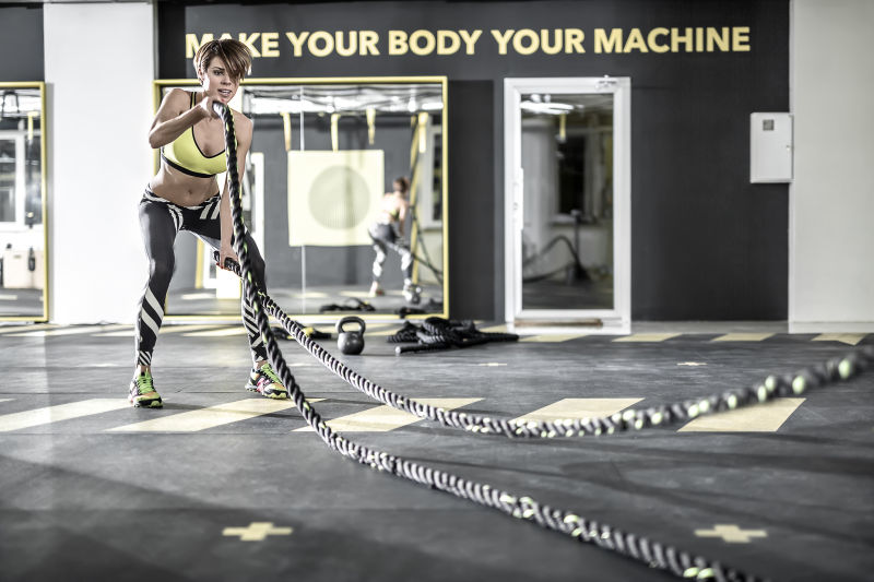 健身房里用健身绳索锻炼的短发女人