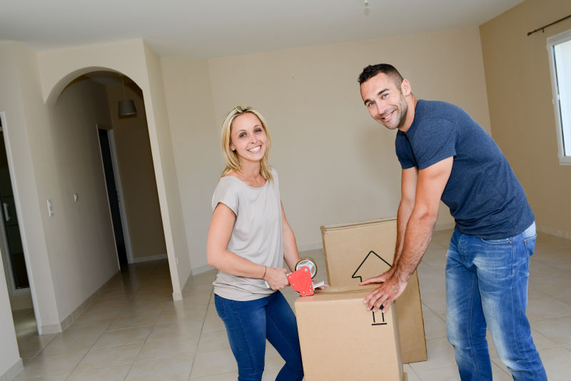 打包纸箱准备搬家的情侣