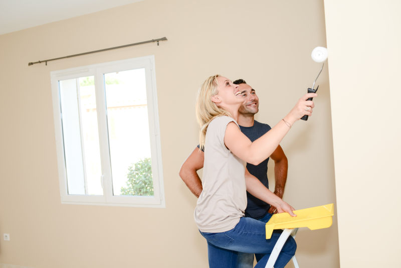 搬家后的年轻夫妇在刷墙