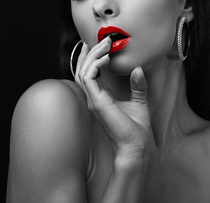 性感年轻女子手指触摸性红唇