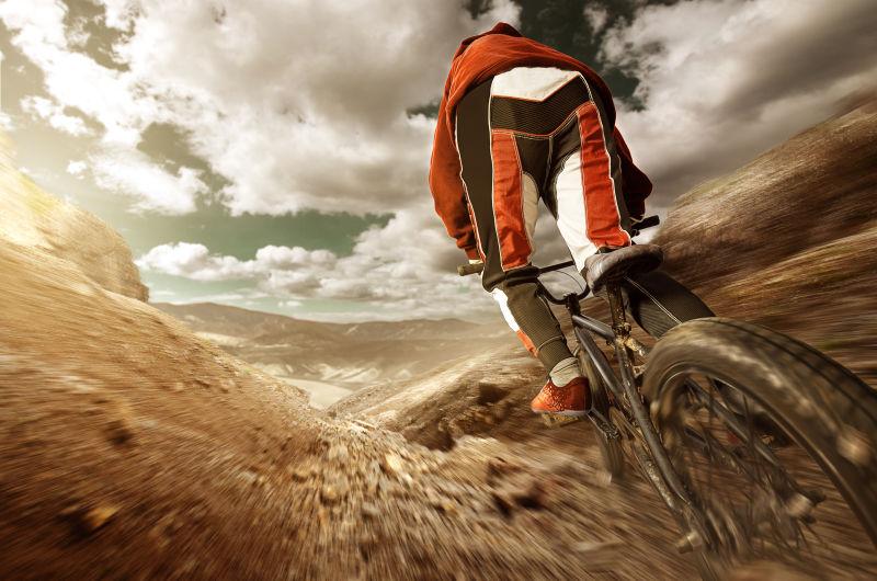 乌云密布的天气下骑车手在下坡骑行自行车