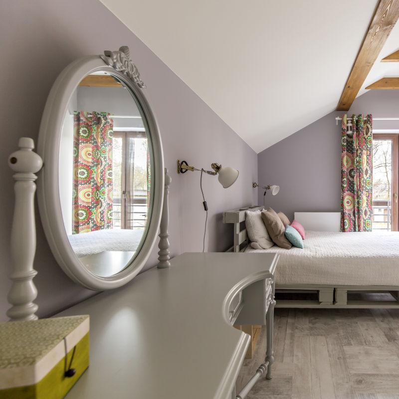一个国王大小的帕莱特床和镜子的宽敞的灰色卧室