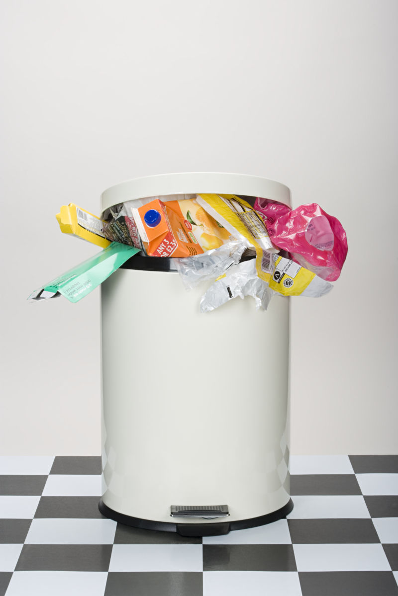 黑白格子地板上的装满垃圾的垃圾桶