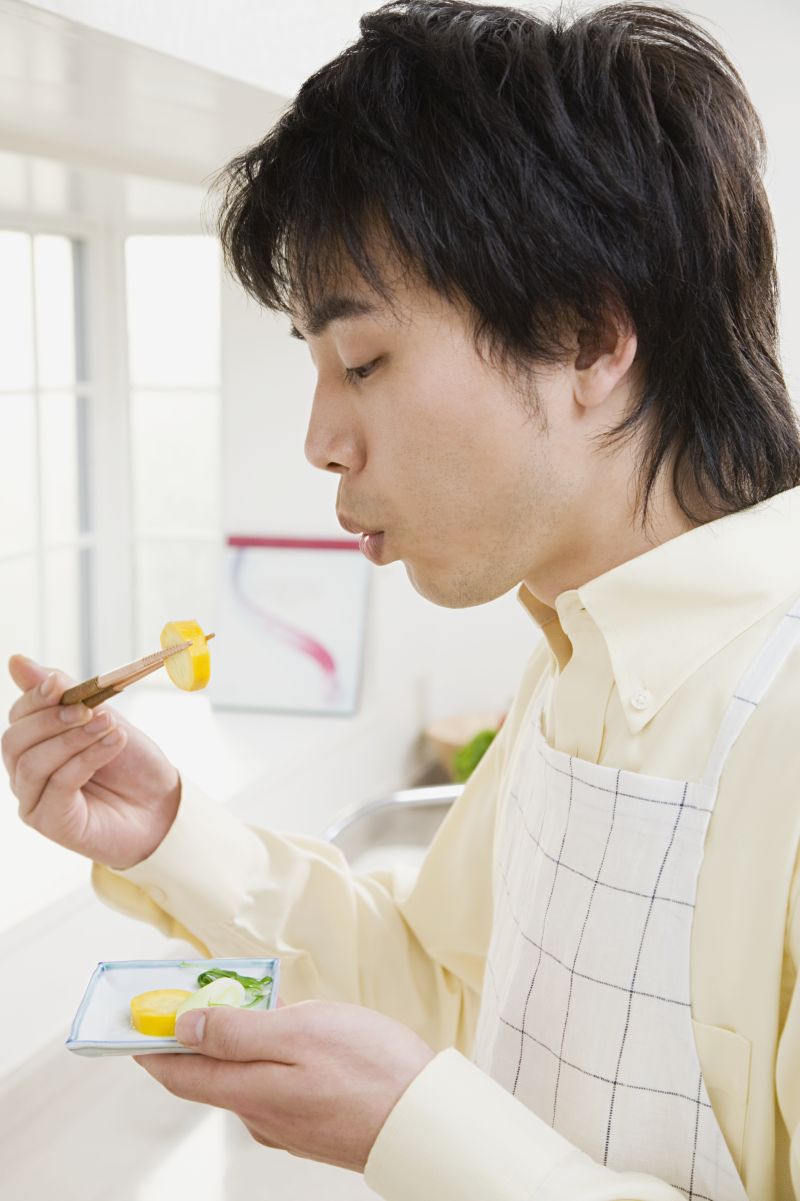 用嘴吹凉食材的男子