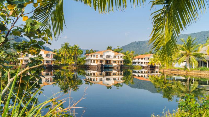 泰国美丽的河流两岸的建筑和棕榈树