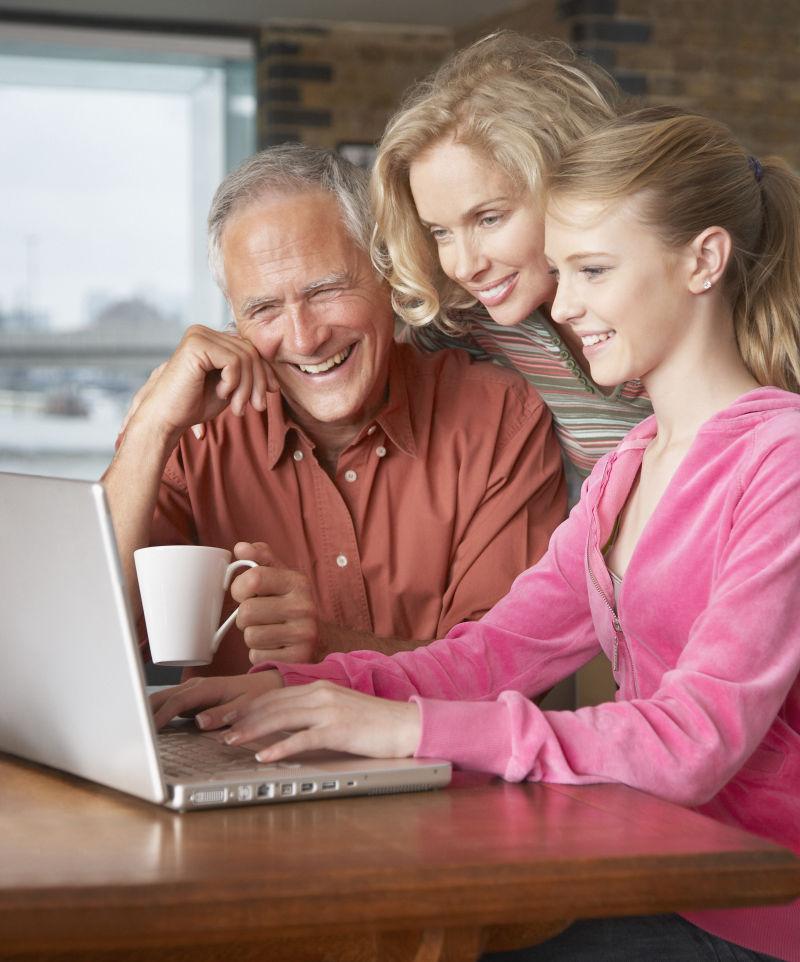 幸福快乐的一家人围在笔记本电脑前