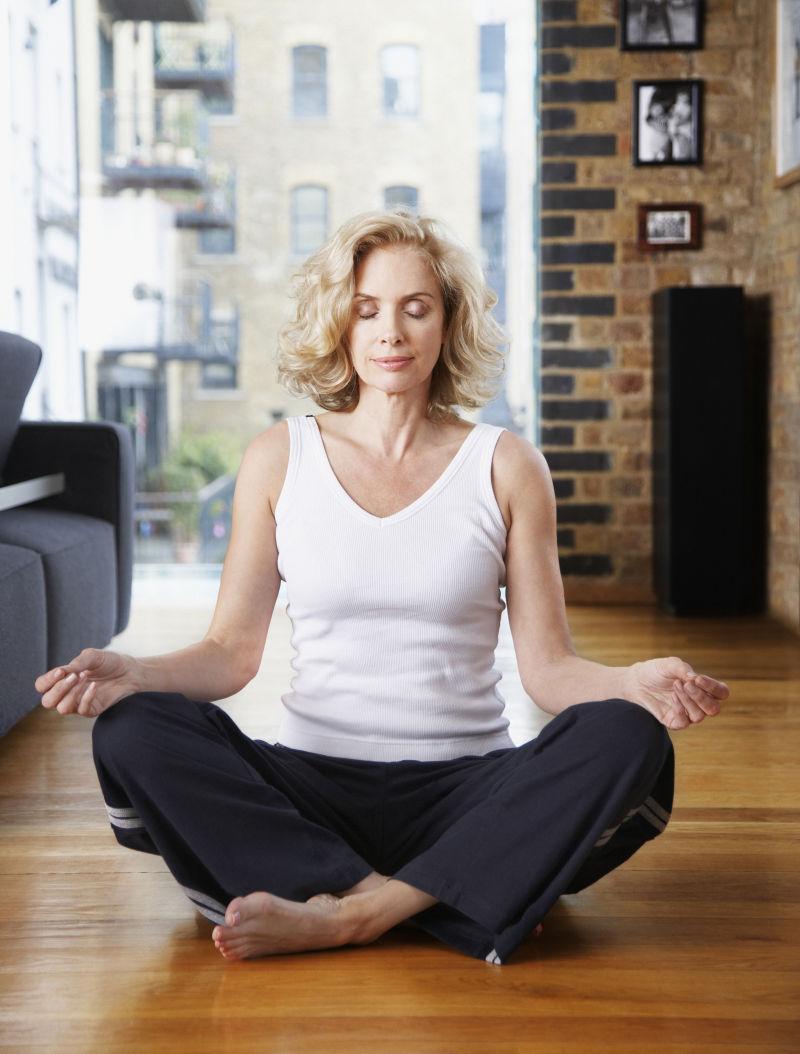 坐在木质地板上冥想的女人