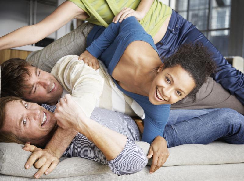 在客厅的沙发上玩耍的年轻男女