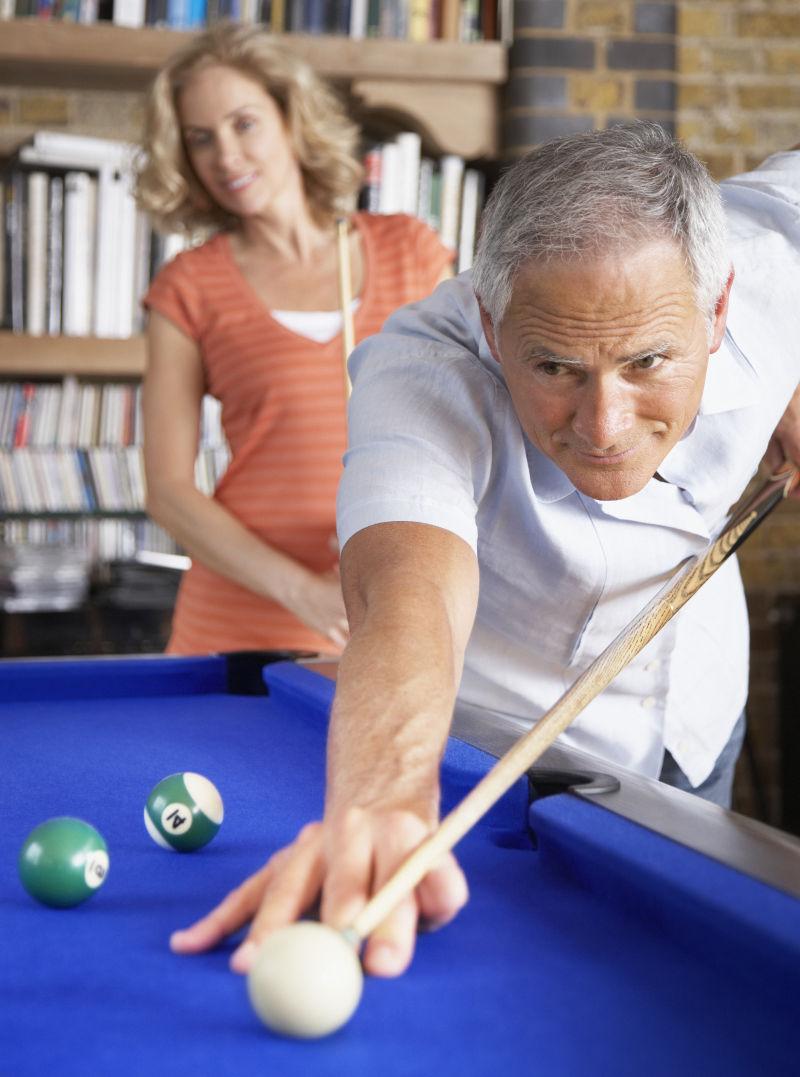 在室内打台球的老夫妻