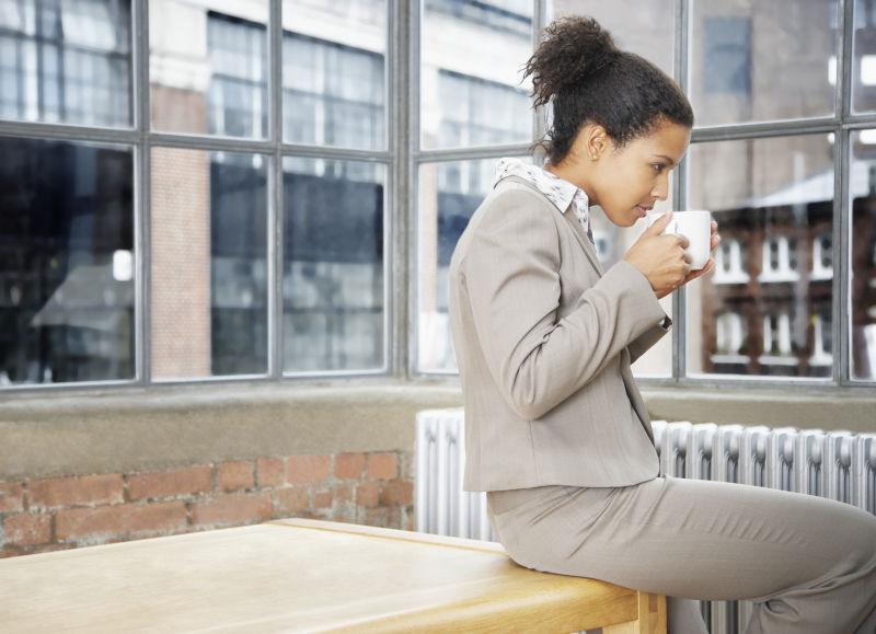 在室内喝水的职业女性