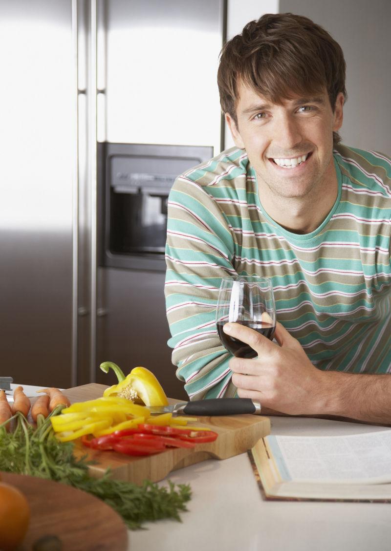 在砧板旁边喝酒的年轻男人