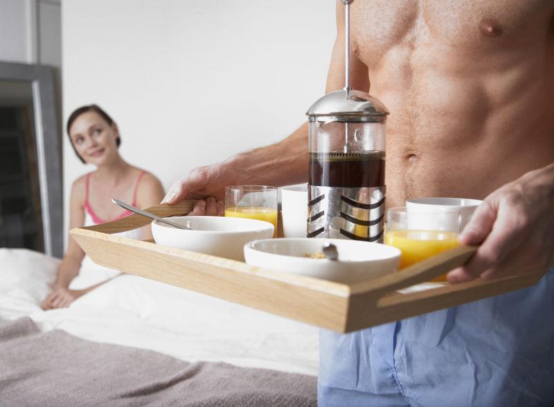 为妻子端上美味早餐的强壮的男士