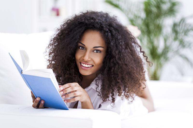 趴在床上看书的年轻非洲女孩