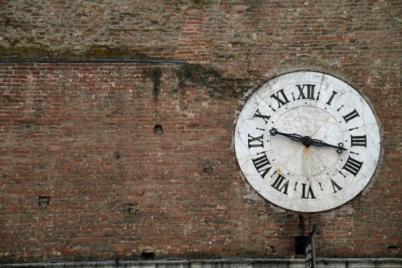 砖墙上的老式古董钟
