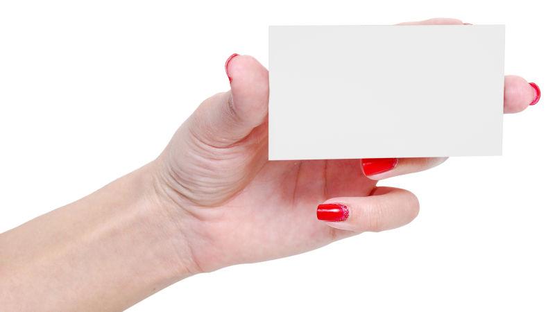 涂着红色指甲的手上拿着白色卡片